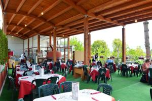 a restaurant with tables and chairs and people sitting at tables at Fortuna Village Pompei in Pompei