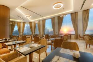 a restaurant with tables and chairs with a view at Vivaldi Hotel in St. Julianʼs