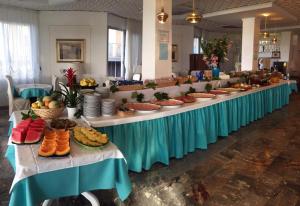 una mesa larga llena de platos y tazones de comida en Hotel Oxford, en Lido di Jesolo