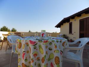 a table with a pineapple table cloth on a patio at Al Ciclamino in Monastir