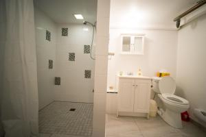 a white bathroom with a toilet and a shower at Maria Montreal in Montreal