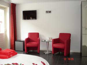 2 sillas rojas y una mesa en una habitación en Cecilia - Catharina B&B en Joure