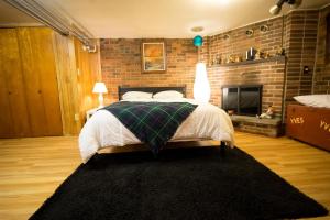 a bedroom with a bed and a brick wall at Maria Montreal in Montreal