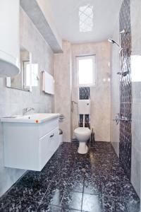 uma casa de banho com um lavatório branco e um WC. em Family Hotel Victoria Gold em Mineralni Bani