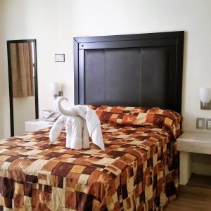 een hotelkamer met een bed met handdoeken erop bij Hotel Posada Guadalupe in Puebla