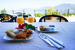 Ein Tisch mit zwei Tellern Essen und zwei Gläsern Orangensaft in der Unterkunft Alykes in Marmarion