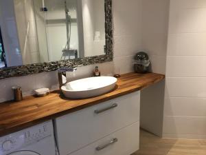 a bathroom with a white sink and a mirror at Appart AQUITANIA, PLAGE in Capbreton