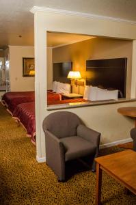 Habitación de hotel con silla y cama en Executive Inn & Suites Sacramento en Sacramento