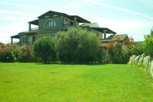 una casa grande en un campo de césped verde en Villa Raffaello, en Porto San Paolo