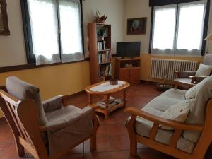 sala de estar con sofá, sillas y mesa en Casa Rural Oihan - Eder, en Espinal-Auzperri