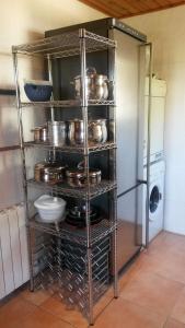 a metal rack with pots and pans in a kitchen at Casa Mar y Piscina (solo familias) in Sant Cebrià de Vallalta