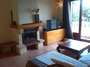 a living room with a fireplace and a tv at Casa Mar y Piscina (solo familias) in Sant Cebrià de Vallalta