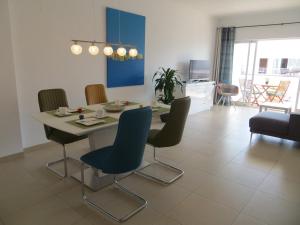 a dining table and chairs in a living room at Formosa Village in Fuzeta
