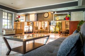 Executive Inn & Suites Sacramento في سكرامنتو: غرفة معيشة فيها طاولة قهوة زجاجية