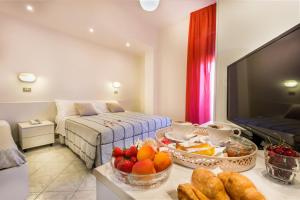 Cette chambre comprend un lit et une table avec des fruits et du pain. dans l'établissement Hotel Ras, à Gatteo a Mare