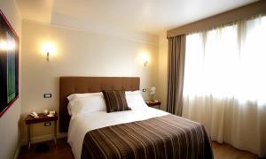 ein Hotelzimmer mit einem Bett und einem Fenster in der Unterkunft Palazzo Giordano Bruno in Nola