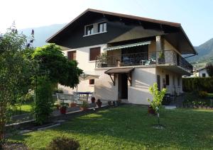 a house with a balcony and a yard at Chez Laurette et Louis in Ugine