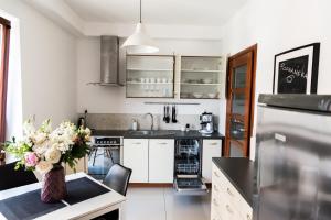 kuchnia z białymi szafkami i wazonem kwiatów na stole w obiekcie 3D Poznańska 6 Apartament w Krakowie