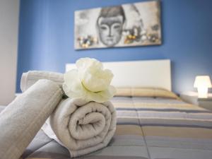 トリノにあるLa Favola Apartmentのベッドの上に置いた白花