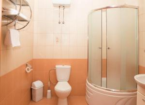 ein Bad mit einer Dusche, einem WC und einem Waschbecken in der Unterkunft Comfort Hotel in Kiew