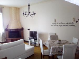 a living room with a chandelier and a table with chairs at Casa Lory in Marone