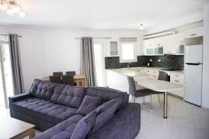 a living room with a couch and a kitchen at Iridanos Apartments in Skiathos Town