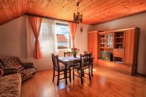 ein Wohnzimmer mit einem Tisch, Stühlen und einem Sofa in der Unterkunft Apartman Josipa in Drežnik Grad