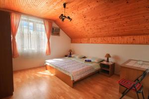sypialnia z łóżkiem i drewnianym sufitem w obiekcie Apartman Josipa w mieście Drežnik Grad