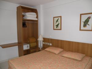 1 dormitorio con cama y estante con toallas en Apartamento Golden Dolphin Grande Hotel - Achei Férias, en Caldas Novas