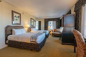 a large hotel room with two beds and a chair at The Brown Hotel in Louisville