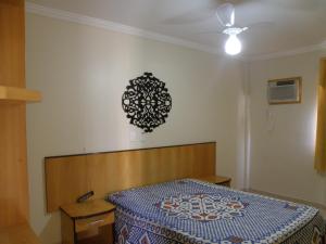 1 dormitorio con 1 cama y una lámpara de araña en la pared en Vitória das Thermas - Achei Férias, en Caldas Novas