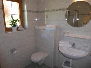 ein Badezimmer mit einem Waschbecken, einem WC und einem Spiegel in der Unterkunft Alpbacher Appartementhaus Johannes in Alpbach