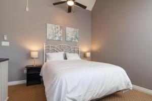 a bedroom with a white bed and a ceiling fan at Mountain Side Condo Loft at The Blue Mountains in Blue Mountains