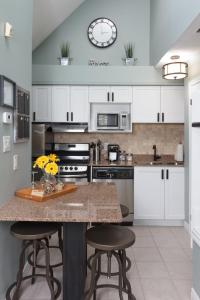 a kitchen with white cabinets and a counter with stools at Mountain Side Condo Loft at The Blue Mountains in Blue Mountains