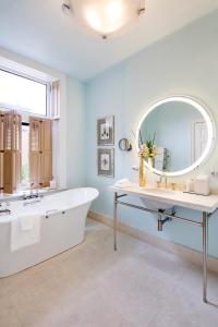 a bathroom with a tub and a large mirror at The Ivy Hotel in Baltimore