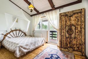 コロビツィノにあるCottage Alpiyskiy domikのベッドルーム1室(ベッド1台付)、大きな木製ドアが備わります。