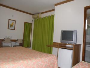 Habitación de hotel con cama y TV en Apartamento Golden Dolphin Grande Hotel - Achei Férias, en Caldas Novas