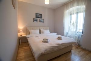 - une chambre avec un lit blanc et une fenêtre dans l'établissement Apartments Saxo, à Kotor