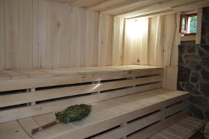 eine Holzbank in einer Sauna mit Pflanze in der Unterkunft Sadyba Pikuy in Belasovitsa