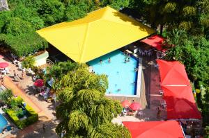 an overhead view of a swimming pool with a yellow umbrella at Sol das Caldas - Achei Férias in Caldas Novas