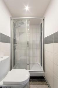 a white bathroom with a shower and a toilet at Sopot Sopot Studio in Sopot
