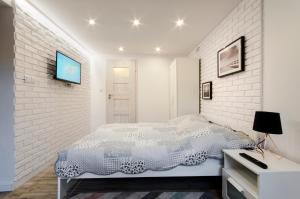 1 dormitorio blanco con 1 cama y TV en la pared en Sopot Sopot Studio, en Sopot