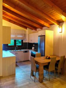 a kitchen with a wooden table and chairs in it at Villa Dimitris in Parga