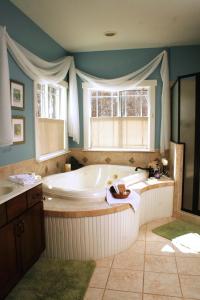 Seven Oaks Inn Bed and Breakfast في هاي بوينت: حمام كبير مع حوض استحمام ونافذة