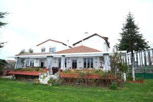 une maison blanche avec une clôture dans une cour dans l'établissement Hôtel Restaurant Maison Blanche, à Rungis