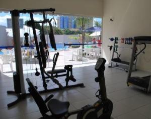 un gimnasio con varias máquinas de correr y una gran ventana en Aguas da Serra - Achei Ferias, en Caldas Novas