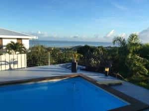 a swimming pool with a view of the ocean at Bungalow Premium Tahiti in Punaauia