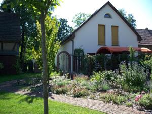 ein Garten vor einem weißen Haus mit einem Tor in der Unterkunft Haus Marcus in Kolkwitz