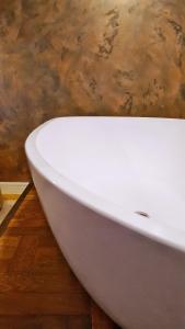 a white bath tub sitting on top of a wooden floor at Bremen Apartments Nath in Bremen