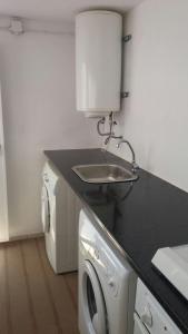 a kitchen with a sink and a washing machine at Casa da Madrinha I in Monte Gordo